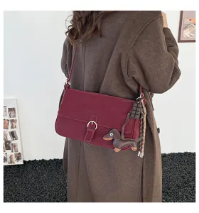Detailed view of a vintage wine red women shoulder bag with cute puppy pendant for daily wear.