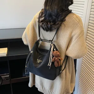 Women black nylon convertible backpack tote bag with cute bear pendant for daily casual use.