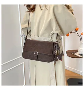 Retro brown suede shoulder bag detail, showcasing elegant daily commute style and charm.