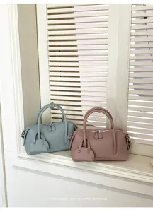 Detailed view of stylish litchi pattern Boston pillow shoulder handbag in soft pastel colors.