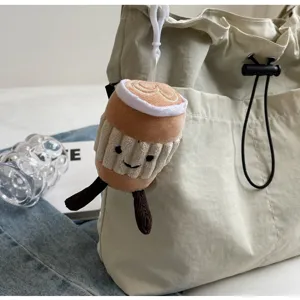 Casual canvas bucket bag with cute plush coffee cup pendant for women daily commute style.