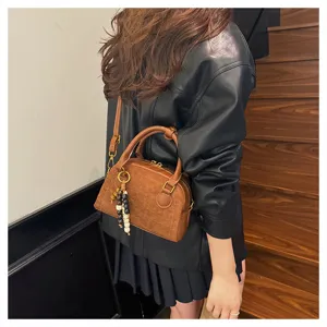 Retro brown leather bowling handbag, chic crossbody shoulder bag with beaded charm detail.