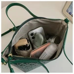 Vue détaillée de l'intérieur du sac fourre-tout vert montrant une grande capacité de stockage.