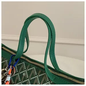 Détail du sac cabas en toile verte avec motif chevron classique, poignées en cuir et fermeture zippée.
