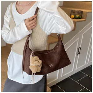 Brown wrinkled baguette shoulder bag for women, chic underarm purse with cute bear pendant.