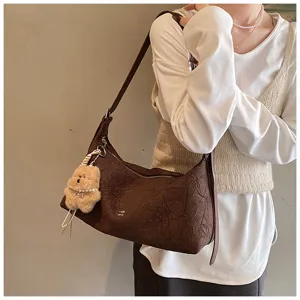 Detailed view of the brown pleated shoulder bag, featuring a cute bear pendant and soft fabric.