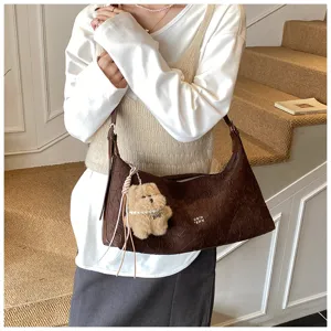Detail view of the vintage crinkled shoulder underarm bag with cute bear charm for women.