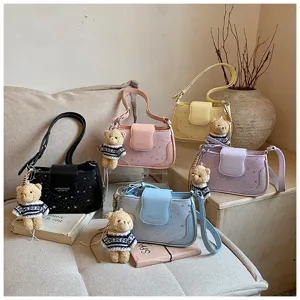 Detailed view of stylish star pattern women shoulder bag with cute teddy bear charm.