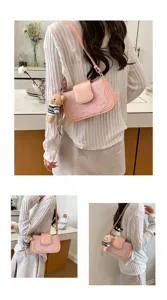 Stylish pink shoulder bag with star pattern and cute bear pendant for women commuting.