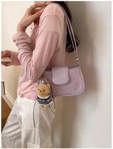 Vue détaillée du sac à bandoulière violet tendance avec motif étoiles et joli pendentif ours.