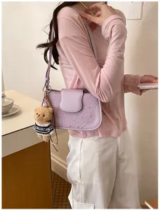 Sac à bandoulière violet tendance avec motif d'étoiles et pendentif ours pour femmes.
