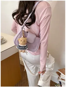 Sac à bandoulière violet clair élégant avec gaufrage d'étoiles et pendentif en peluche d'ours mignon.