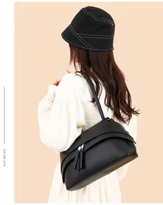 Stylish black underarm shoulder bag worn by model, showcasing premium vintage texture.