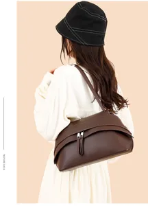 Detailed view of the retro brown leather underarm shoulder bag with metal zipper and stylish tassels.