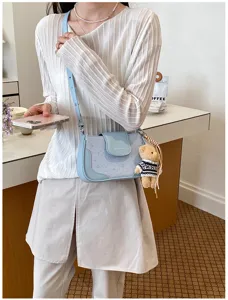 Vue détaillée du sac bandoulière bleu clair imprimé d'étoiles avec adorable pendentif d'ours.