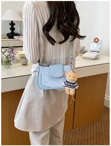 Sac à bandoulière bleu clair chic pour femmes avec motif d'étoiles et pendentif ours.