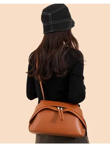 Detailed view of stylish brown leather underarm bag with zipper closure for daily retro chic outfit.