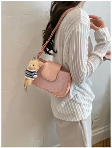 Sac à bandoulière rose avec détails d'étoiles et joli pendentif d'ours pour femmes.
