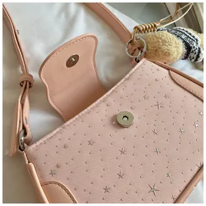 Gros plan détaillé du sac à bandoulière rose étoilé avec fermoir magnétique élégant.