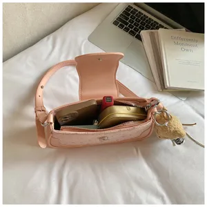 Détail de sac à bandoulière rose imprimé étoiles avec pendentif ours mignon et rangement.