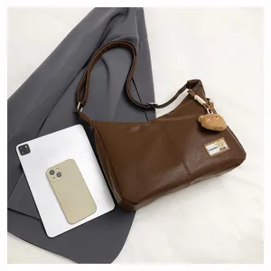 Retro brown soft dumpling bag detail view with cute bear pendant and daily commuter style.