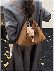 Brown frosted leather multifunctional backpack detail shot with cute plush dog pendant.