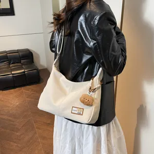 White slouchy shoulder hobo bag, stylish soft leather dumpling bag with cute bear pendant.