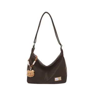 Retro soft leather hobo dumpling bag with cute bear pendant, stylish casual shoulder bag.