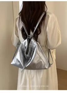 Zaino tote argentato minimalista, finitura metallica premium, vista dettaglio chic.