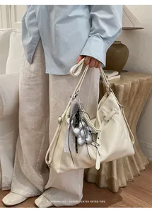 Vista dettagliata della borsa tote vintage in pelle PU con ciondolo in stile retrò.
