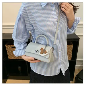 Chique lichtblauwe schoudertas crossbody tas voor dames met leuk schommelpaard hanger.