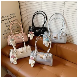 Detailed view of fashionable leather shoulder bags with cute bear pendants and metal rivets.