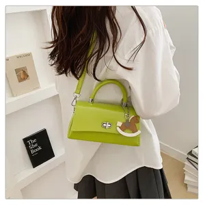 Groene schoudertas detail met metalen draaisluiting en schattige schommelpaard hanger voor dames.