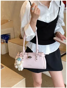 Stylish pink PU leather shoulder bag for women with chic rivets, turn-lock and cute bear pendant detail.