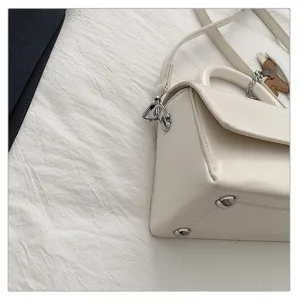 Modieuze witte dames schoudertas, elegante handtas met kleine vierkante tas detail.