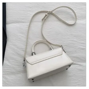 Witte schoudertas detail, chique trapezoidale ontwerp met zilveren metalen hardware.