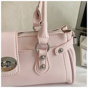 Pink leather shoulder bag detail, elegant hardware lock and rivet design, chic commute handbag.