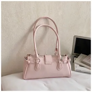 Close-up detail of the pink leather underarm shoulder bag showcasing double handles and metal buckles.