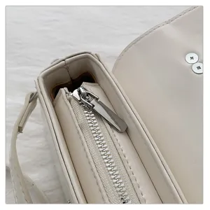 Gedetailleerd overzicht van witte dames schoudertas, rits en metalen hardware, PU leer.