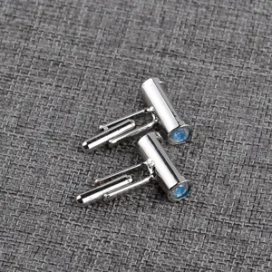 Silver metal cuff links detail shot showing the classic T-bar design and blue decor.