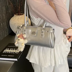 Silver metallic shoulder bag with stylish studs and cute bear charm for women daily commute.