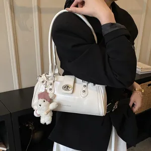 White underarm shoulder bag for women, stylish rivet design with cute bear pendant and lock.