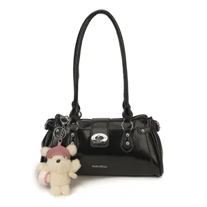 Stylish black patent leather shoulder bag for women with metal rivets and cute bear pendant.