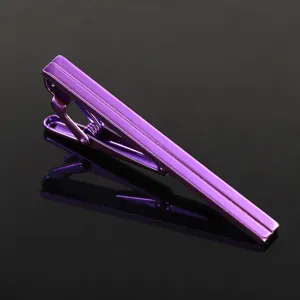 Gros plan d'une pince à cravate en métal violet vif pour homme au design élégant et moderne.