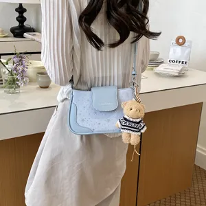 Sac à bandoulière bleu clair élégant avec motif d'étoiles et joli pendentif ours pour femme.