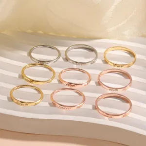 Minimalist metal rings detail shot, featuring engraved lettering and elegant finishes for daily wear.