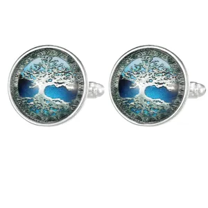 Detailed view of silver tone round glass cabochon cufflinks featuring tree of life art design.