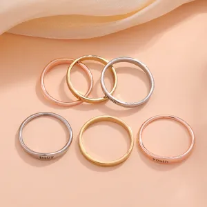 Minimalist copper rings with engraved letters, chic stackable metal finger jewelry detail.
