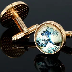 Macro detail view of luxury gold-plated round cufflinks featuring a classic wave art design.