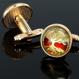 Close-up detail of gold-toned metal cufflinks featuring a round tree of life art glass cabochon.